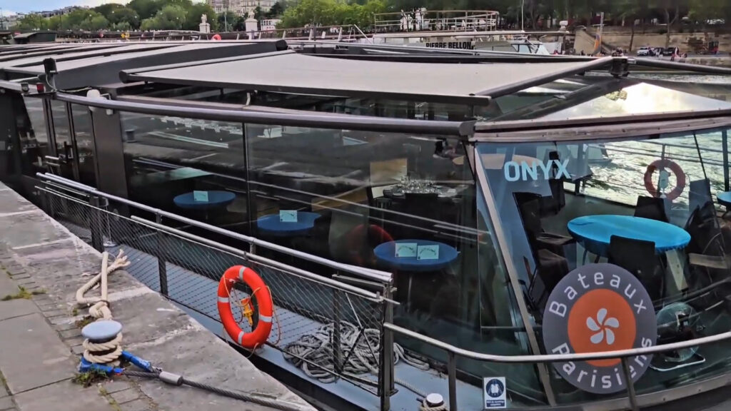 Vue du point d'embarquement des Bateaux Parisiens au pied de la Tour Eiffel avec les passagers en file d'attente