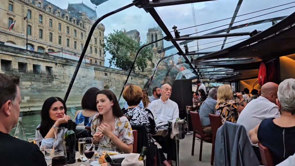 Vue de la salle à manger du bateau avec tables dressées, baies vitrées et plafond de verre