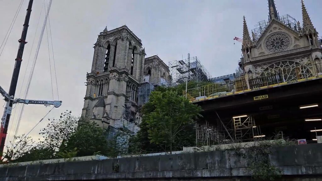 Vue du pont découvert avec passagers admirant Paris, rambarde au premier plan, monuments en arrière-plan