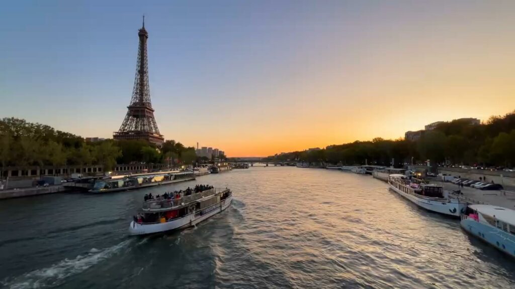 Vue depuis le pont d'une croisière montrant la Seine illuminée avec la Tour Eiffel en arrière-plan et des ponts parisiens