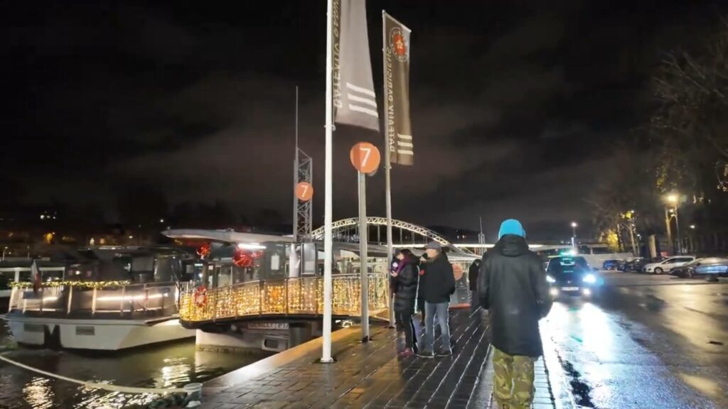 Vue du quai d'embarquement près de la Tour Eiffel avec panneau indiquant le point de départ