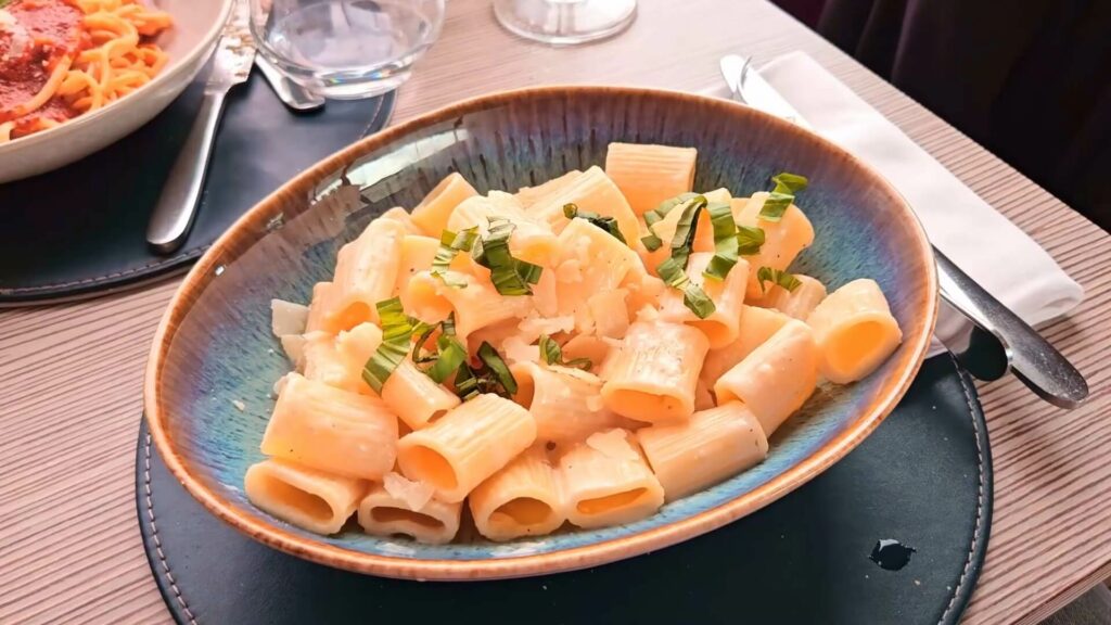 Assiette de ravioli trois fromages servi à bord avec décor de table et vue Seine en arrière-plan